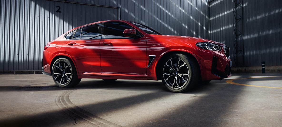 BMW X4 M F98 LCI Facelift 2021 Toronto Rot metallic Seitenansicht vor Fabrikhalle